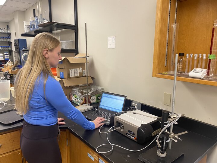A woman at an instrument in a lab.