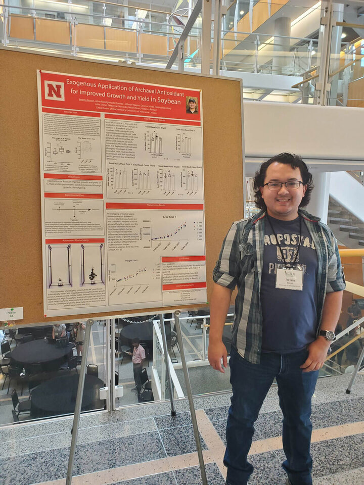 A graduate student in front of his research poster.
